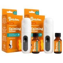 Two white ultrasonic diffusers with black buttons and two amber bottles of calming solution with black caps, displayed with o