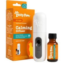 White Zesty Paw calming diffuser with black accents next to amber bottle of orchid mist refill and orange product packaging.